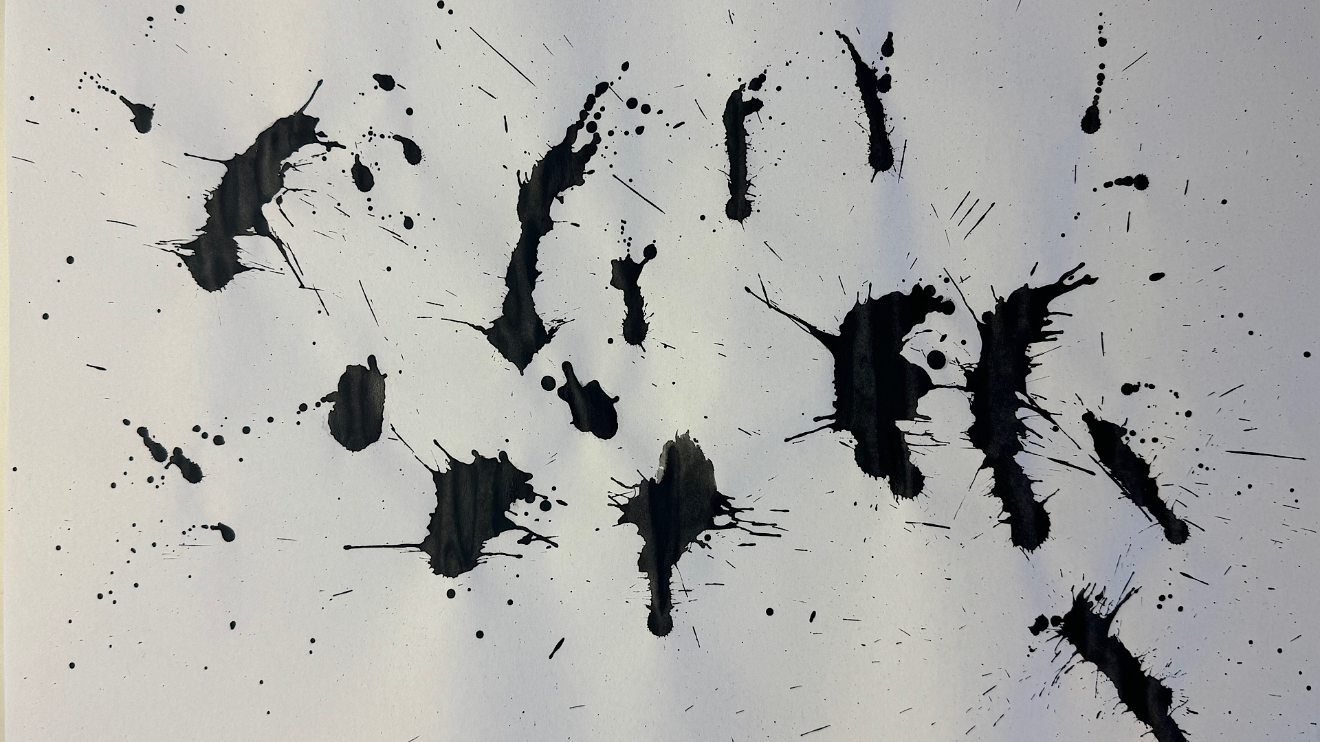 Black paint splashes on white paper
