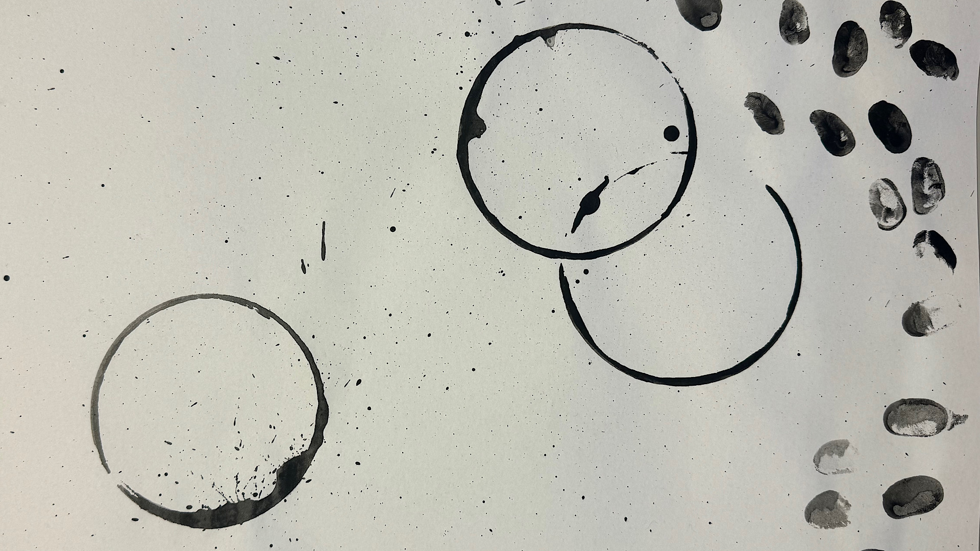 Fingerprints and rings from mugs on a white paper
